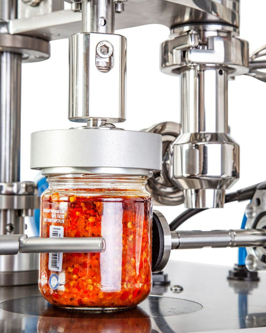 A jar of red chilli preserve in a filling machine
