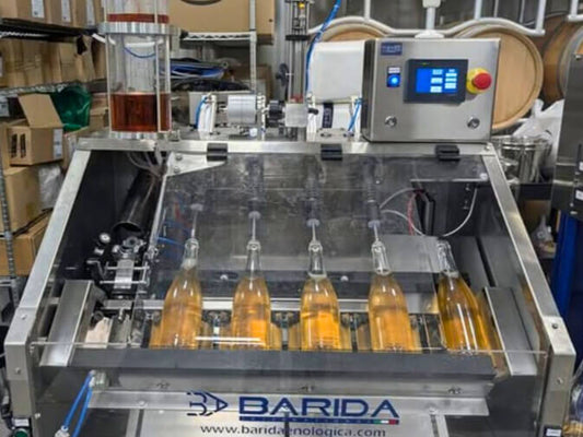 Five bottles in the Barida Muima TG semi automatic disgorging, dosing & topping, corking & muzzling machine.