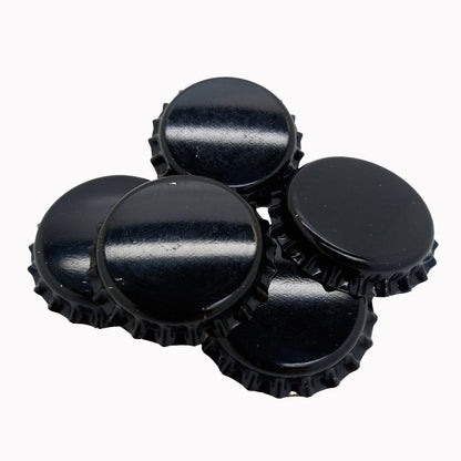 Stack of black crown caps for bottles on a white background