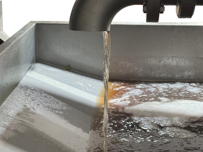 Close-up of grape juice running from the drain on the Sphera grape press by Willmes. 